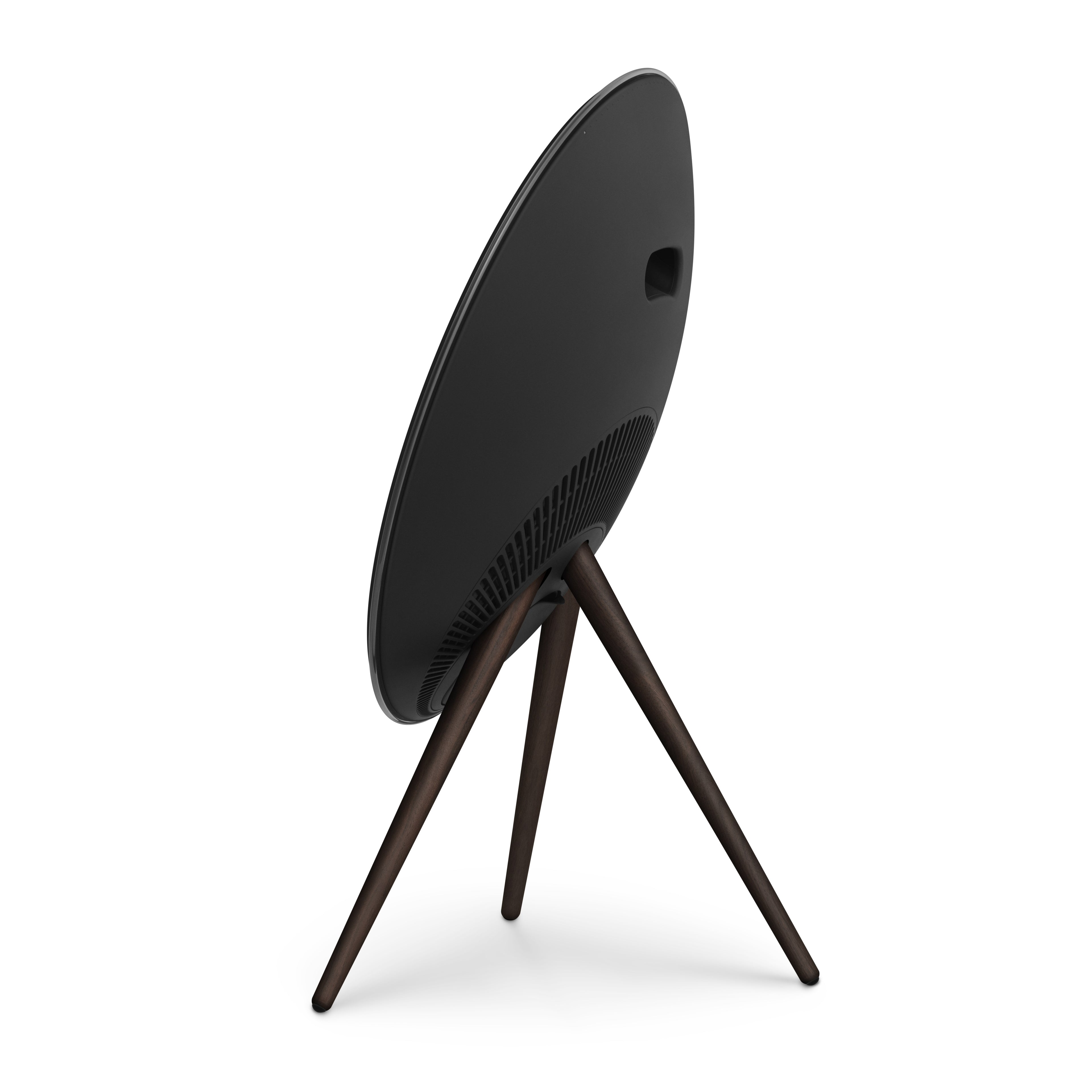Dreiviertel-Ansicht der Rückseite einer Bang & Olufsen Beosound A9 in Black Anthracite. Das Bild betont das elegante, schwarze Polymer-Gehäuse, den integrierten Tragegriff und die markante Linienführung der dunklen Nussbaumholz-Beine. Freigestellt auf weißem Hintergrund für eine hochwertige Produktpräsentation.