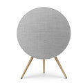 Frontalansicht der Beosound A9 in Natural Aluminium. Der silberne Rahmen umschließt ein lichtgraues Textil-Cover, getragen von Stativbeinen aus heller Eiche. Ein Inbegriff für skandinavisches Design-HiFi.