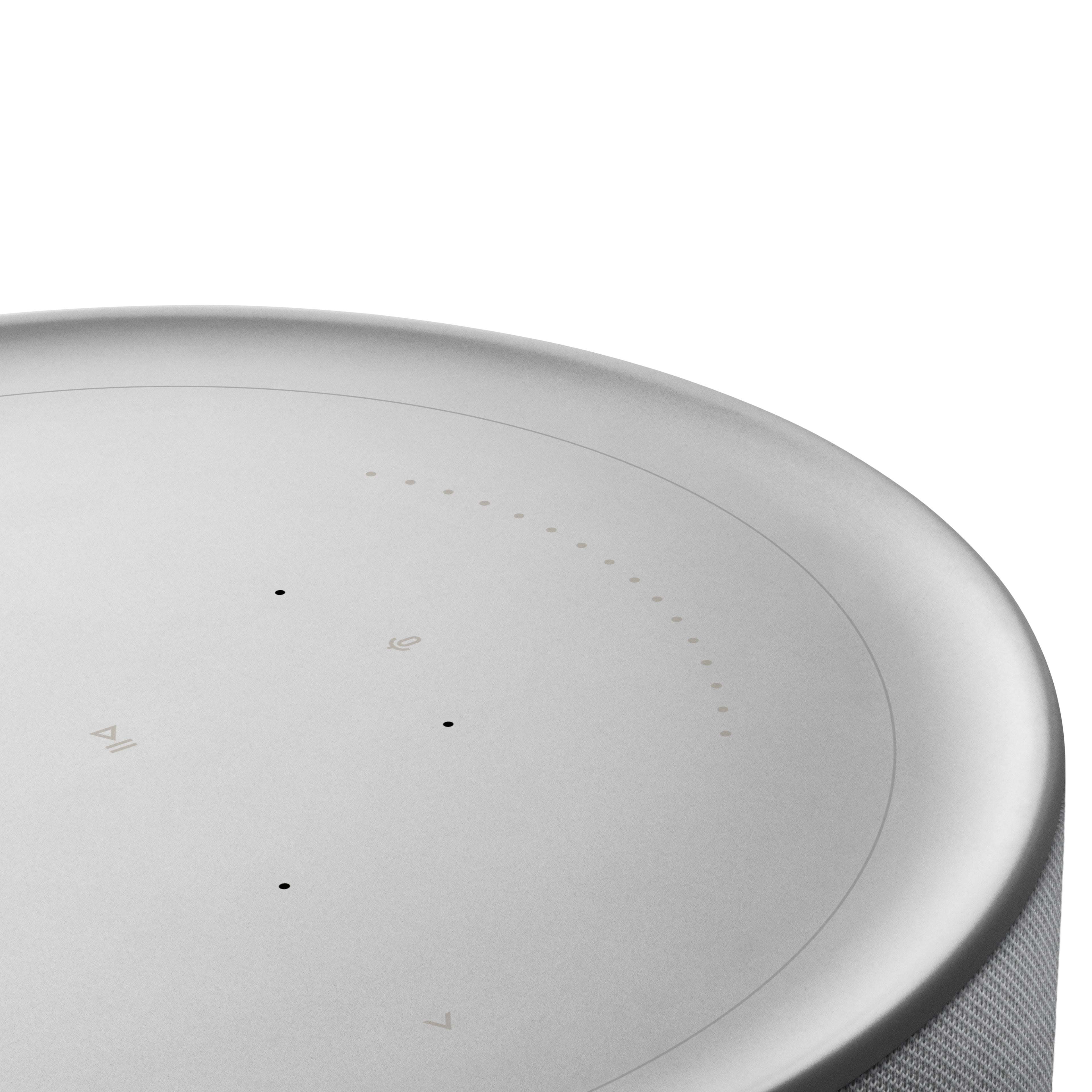 Detailaufnahme der Touch-Bedienoberfläche des Bang & Olufsen Beosound Balance in Natural Aluminium. Zu sehen ist die präzise Aluminium-Oberseite mit dezent hinterleuchteten Symbolen für Play/Pause, Lautstärkeregelung und Mikrofon-Steuerung.